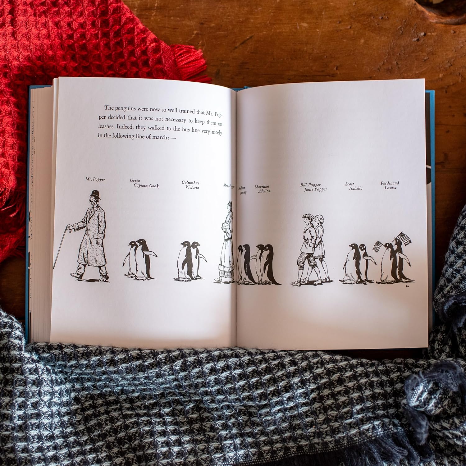 Open book with illustrations of penguins on a textured surface