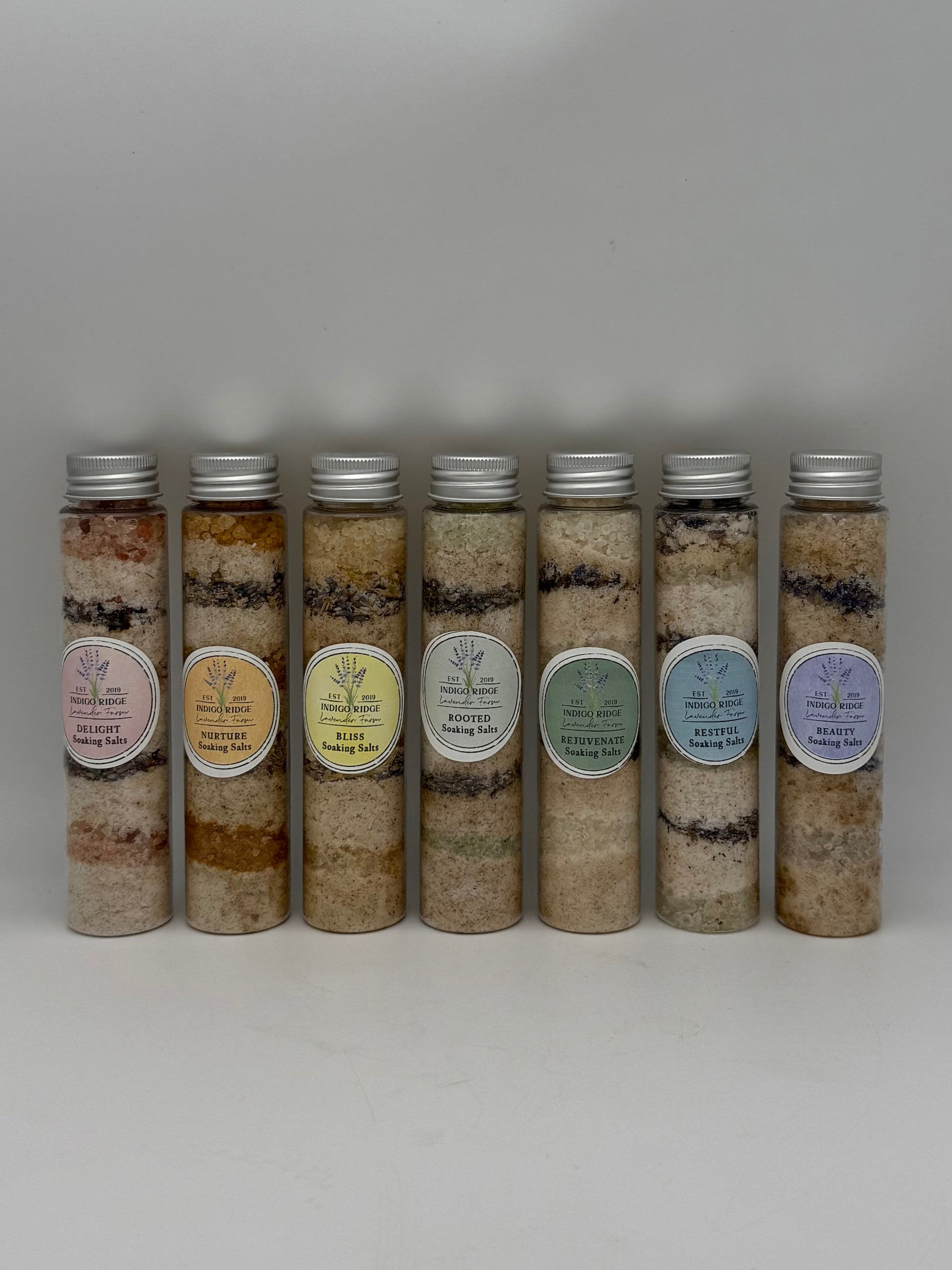 Row of cylindrical containers of layered bath salts from Indigo Ridge