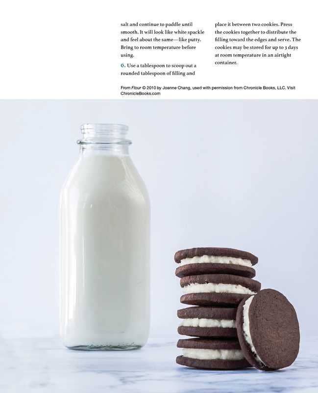 Glass bottle of milk and stack of cookies on a marble surface with text overlay